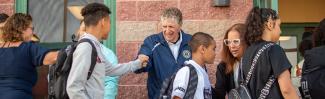 Governor greeting students outside a school